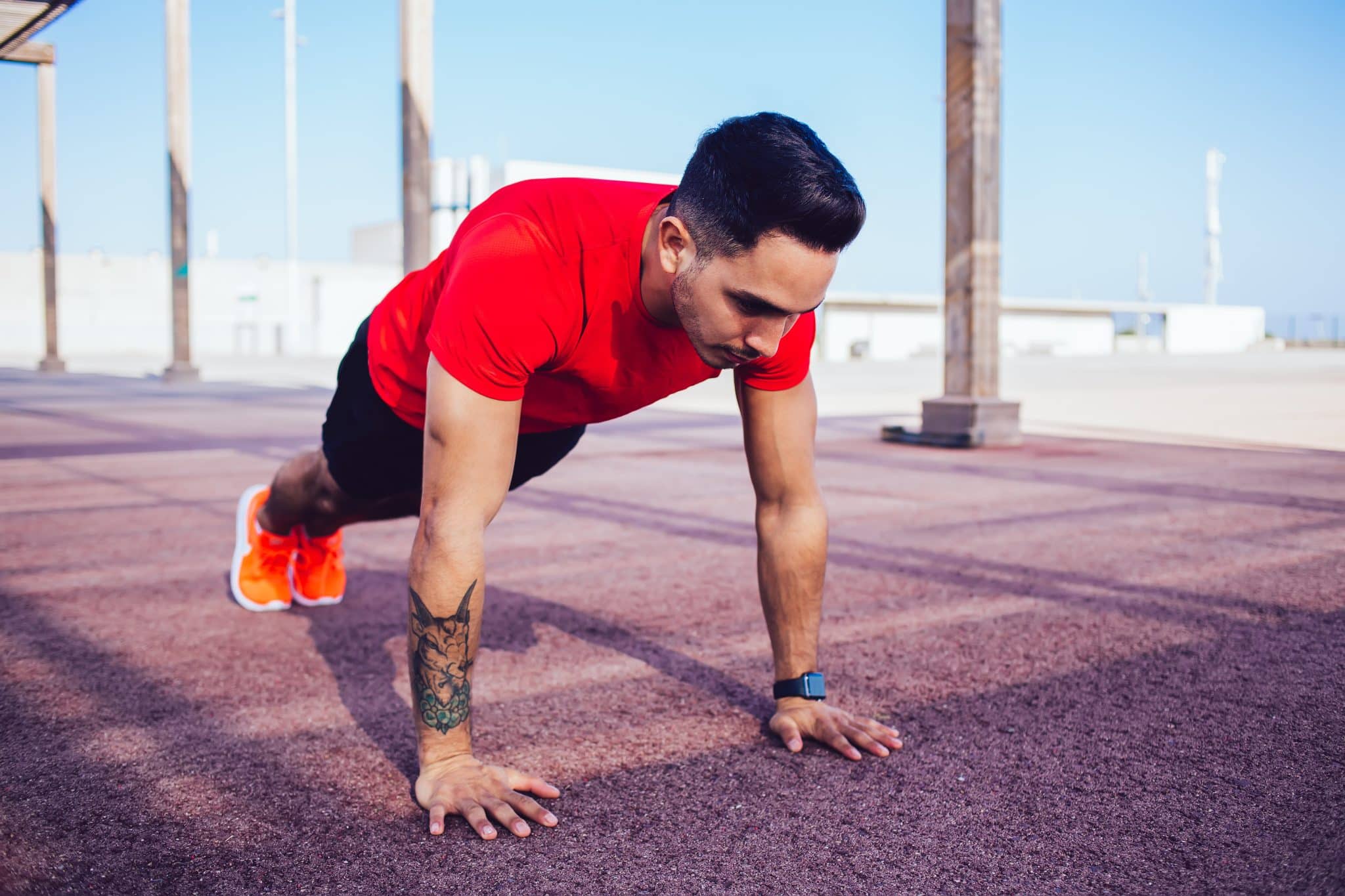 Sportive young Hispanic man working out in street