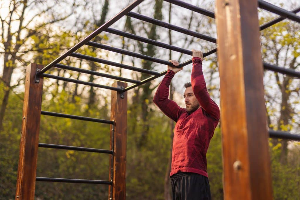Man doing pull ups while doing an outdoor workout