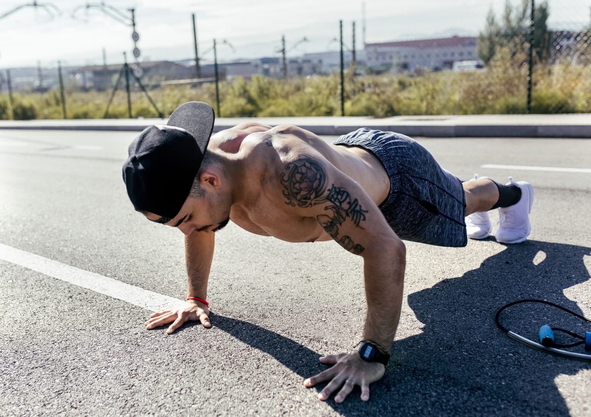 Young man doing push ups on a road